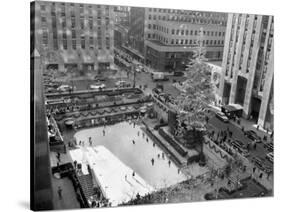 With the Famed Rockefeller Center Christmas Tree Rising Above Them, Skaters Glide on the Ice-null-Stretched Canvas