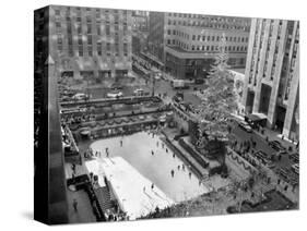 With the Famed Rockefeller Center Christmas Tree Rising Above Them, Skaters Glide on the Ice-null-Stretched Canvas