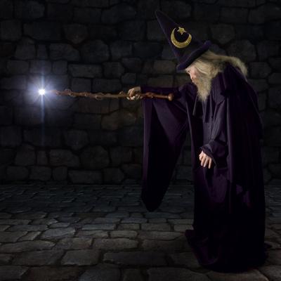 'Wizard in a Purple Robe and Wizard Hat Casting a Spell with His Wand