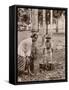 Woman and Young Boy Tap Rubber Trees in Malaya and Collect the Sap in Buckets-null-Framed Stretched Canvas