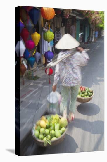 Woman Carrying Fruit Along Street, Hoi An, Quang Nam, Vietnam, Indochina, Southeast Asia, Asia-Ian Trower-Stretched Canvas