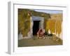 Woman Cooking Outside House with Painted Walls, Village Near Jaisalmer, Rajasthan State, India-Bruno Morandi-Framed Photographic Print