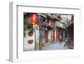 Woman cycling along alleyway, Lijiang (UNESCO World Heritage Site), Yunnan, China-Ian Trower-Framed Photographic Print