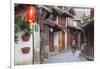 Woman cycling along alleyway, Lijiang (UNESCO World Heritage Site), Yunnan, China-Ian Trower-Framed Photographic Print