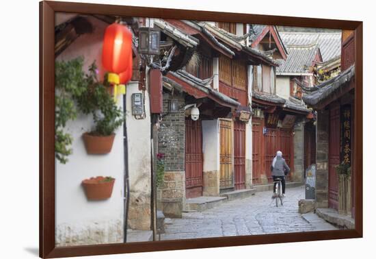 Woman cycling along alleyway, Lijiang (UNESCO World Heritage Site), Yunnan, China-Ian Trower-Framed Photographic Print