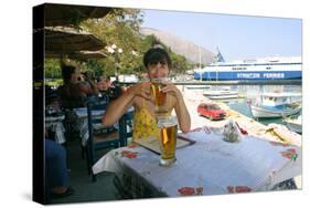 Woman Enjoying a Drink in a Harbourside Taverna, Poros, Kefalonia, Greece-Peter Thompson-Stretched Canvas