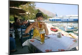 Woman Enjoying a Drink in a Harbourside Taverna, Poros, Kefalonia, Greece-Peter Thompson-Mounted Photographic Print