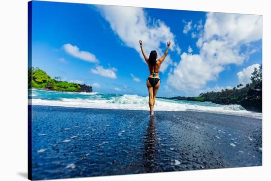 Woman enjoying the sun on one of Maui's black sand beaches, Hawaii-Laura Grier-Stretched Canvas