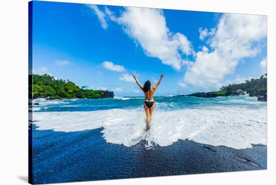 Woman enjoying the sun on one of Maui's black sand beaches, Maui, Hawaii-Laura Grier-Stretched Canvas