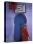 Woman Exits thru Moorish-Style Blue Door, Morocco-Merrill Images-Stretched Canvas