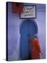 Woman Exits thru Moorish-Style Blue Door, Morocco-Merrill Images-Stretched Canvas