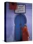 Woman Exits thru Moorish-Style Blue Door, Morocco-Merrill Images-Stretched Canvas