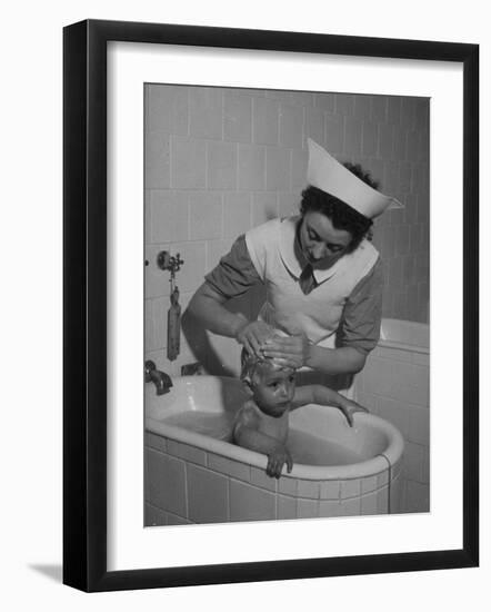 Woman Giving a Baby a Bath at a Nursery-null-Framed Photographic Print