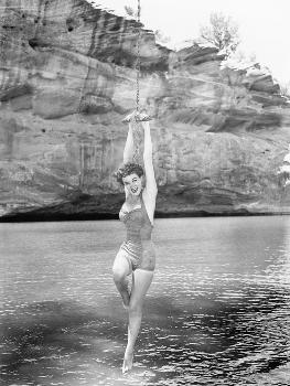 Woman Hanging from Rope Swing over Water' Photo