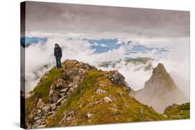 Woman high atop cloudy Harbor Mountain, Sitka, Alaska-Mark A Johnson-Stretched Canvas