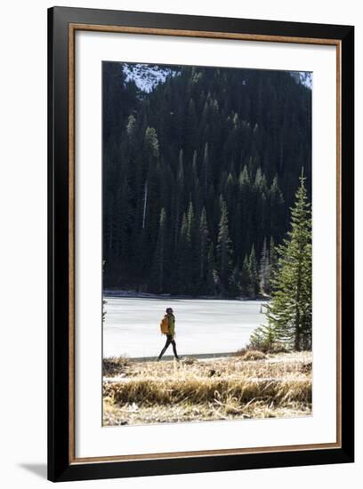 Woman Hiker Walks Alongside A Frozen Lake In The Olympic Mountain High Country During Winter In WA-Hannah Dewey-Framed Photographic Print