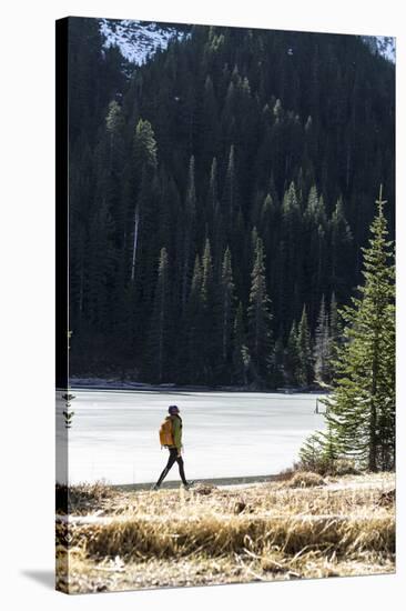 Woman Hiker Walks Alongside A Frozen Lake In The Olympic Mountain High Country During Winter In WA-Hannah Dewey-Stretched Canvas