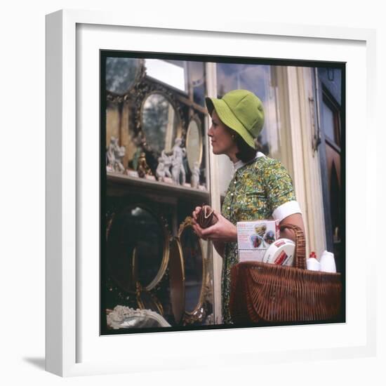 Woman in a Green Floppy Hat and Green Dress Browses in a Shop Selling Various Mirrors and Ornaments-null-Framed Art Print