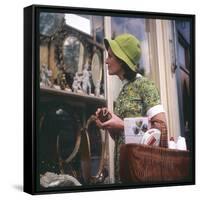 Woman in a Green Floppy Hat and Green Dress Browses in a Shop Selling Various Mirrors and Ornaments-null-Framed Stretched Canvas