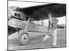 Woman in Sunglasses Waving a Flag on the Tarmac Next to a Airplane-null-Mounted Photo