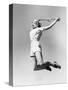 Woman Jumping into the Air with a Tennis Racket in Her Hand-null-Stretched Canvas