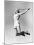 Woman Jumping into the Air with a Tennis Racket in Her Hand-null-Mounted Photo