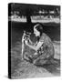 Woman Kneeling on the Lawn Playing with a Tame Raccoon-null-Stretched Canvas