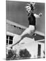 Woman Leaping over a Tennis Net-null-Mounted Photo