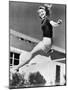 Woman Leaping over a Tennis Net-null-Mounted Photo