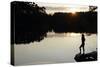 Woman looking out across a lake in rural Finland-David Pickford-Stretched Canvas