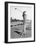 Woman on the Driving Range Swinging a Golf Club-null-Framed Photo