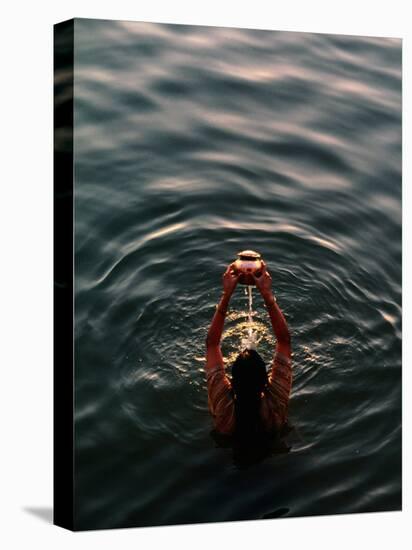 Woman Pouring Water During Morning Puja on Ganges, Varanasi, India-Anthony Plummer-Stretched Canvas