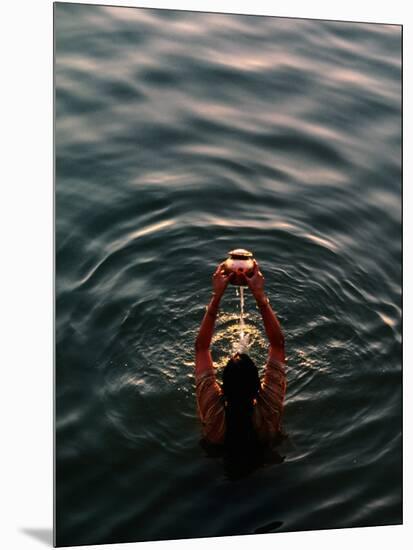 Woman Pouring Water During Morning Puja on Ganges, Varanasi, India-Anthony Plummer-Mounted Photographic Print