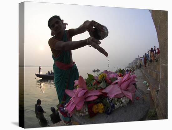 Woman Pouring Water Over Flowers on an Altar as a Religious Ritual, Varanasi, India-Eitan Simanor-Stretched Canvas
