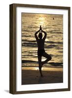 Woman practising yoga meditation on beach at sunset as concept for silence and relaxation-Godong-Framed Photographic Print