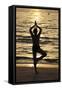 Woman practising yoga meditation on beach at sunset as concept for silence and relaxation-Godong-Framed Stretched Canvas