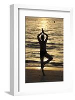 Woman practising yoga meditation on beach at sunset as concept for silence and relaxation-Godong-Framed Photographic Print