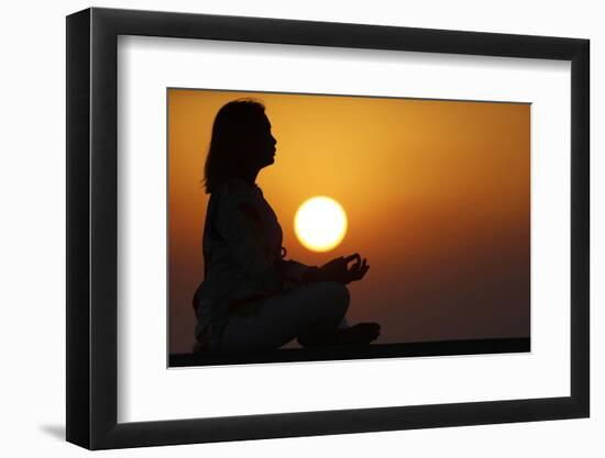 Woman practising yoga pose and meditation at sunset as concept for silence and relaxation-Godong-Framed Photographic Print