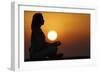 Woman practising yoga pose and meditation at sunset as concept for silence and relaxation-Godong-Framed Photographic Print