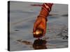 Woman Praying on the Banks of the River Ganges Fills Water into a Copper Vessel for a Ritual-null-Stretched Canvas