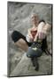 Woman Putting on Rock Climbing Shoes-Anthony West-Mounted Photographic Print