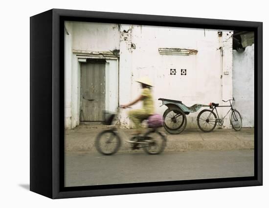 Woman Riding Bicycle Along Street, Ben Tre, Vietnam-Ian Trower-Framed Stretched Canvas