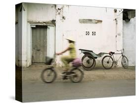 Woman Riding Bicycle Along Street, Ben Tre, Vietnam-Ian Trower-Stretched Canvas