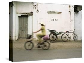 Woman Riding Bicycle Along Street, Ben Tre, Vietnam-Ian Trower-Stretched Canvas