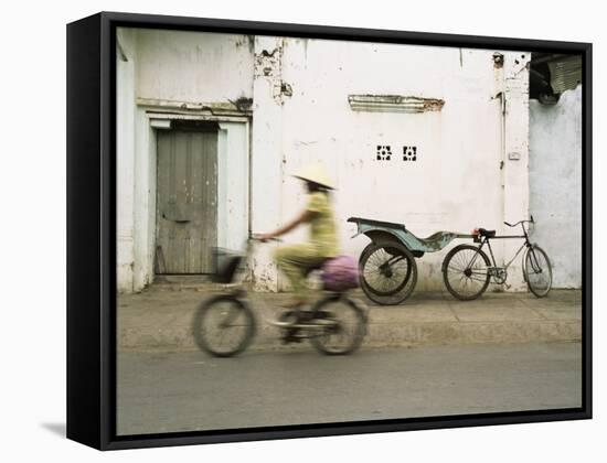 Woman Riding Bicycle Along Street, Ben Tre, Vietnam-Ian Trower-Framed Stretched Canvas