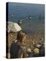 Woman's Back Covered with Mud and People Floating in the Sea in Background, Dead Sea, Israel-Eitan Simanor-Stretched Canvas