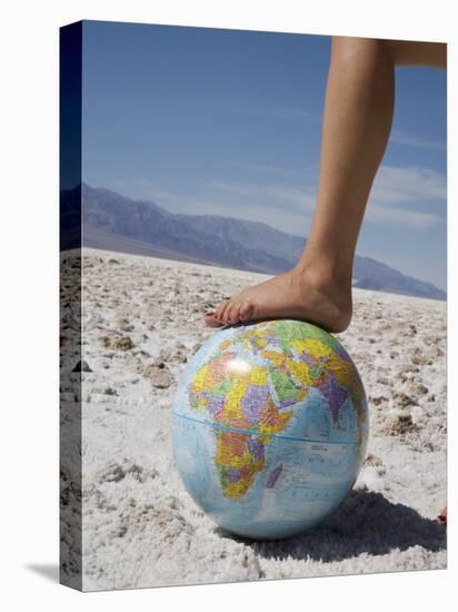 Woman's Foot on Globe, Bad Waters Point, Death Valley National Park, California, USA-Angelo Cavalli-Stretched Canvas