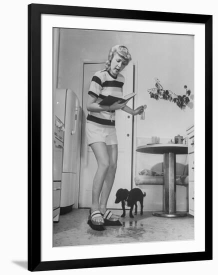 Woman Scrubbing Kitchen Floor with Brushes Attached to Her Feet-Allan Grant-Framed Photographic Print