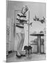 Woman Scrubbing Kitchen Floor with Brushes Attached to Her Feet-Allan Grant-Mounted Photographic Print