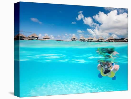 Woman Snorkeling in Clear Tropical Waters in Front of Overwater Villas-BlueOrange Studio-Stretched Canvas